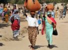 Cameroon Peul women carrying heavy load on their head