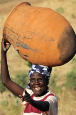 Cameroon woman carrying heavy water jar